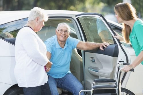 (credit: Getty Images) caregiver assisting man out of car and into wheelchair