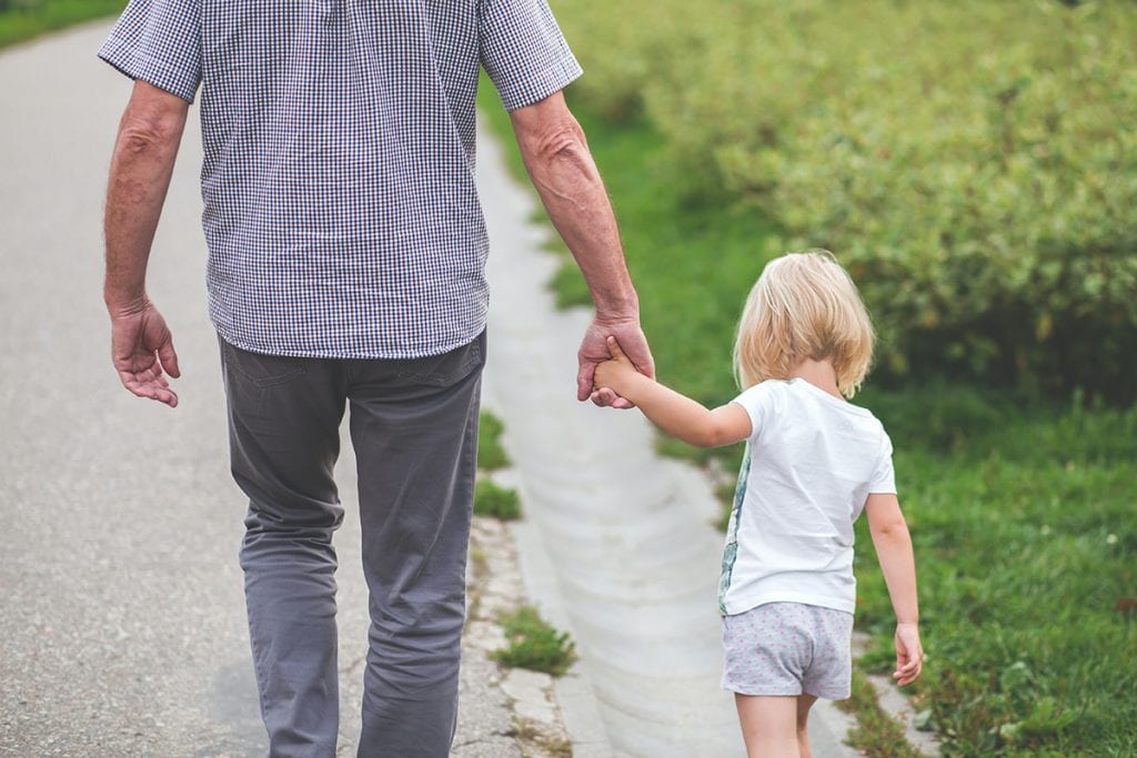 man and child walking holding hands