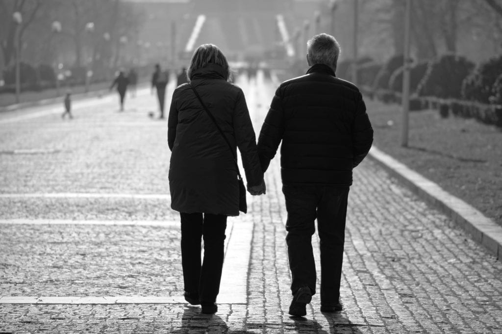 man and woman walking on sidewalk