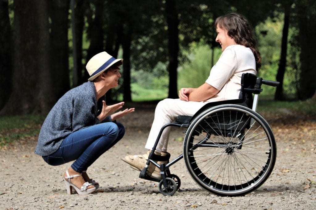 woman talking to lady in wheelchair