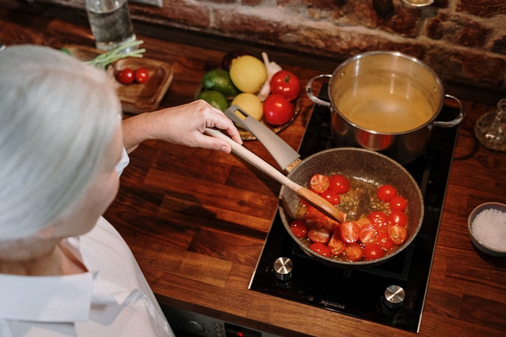(credit cottonbro) woman cooking tomatoes